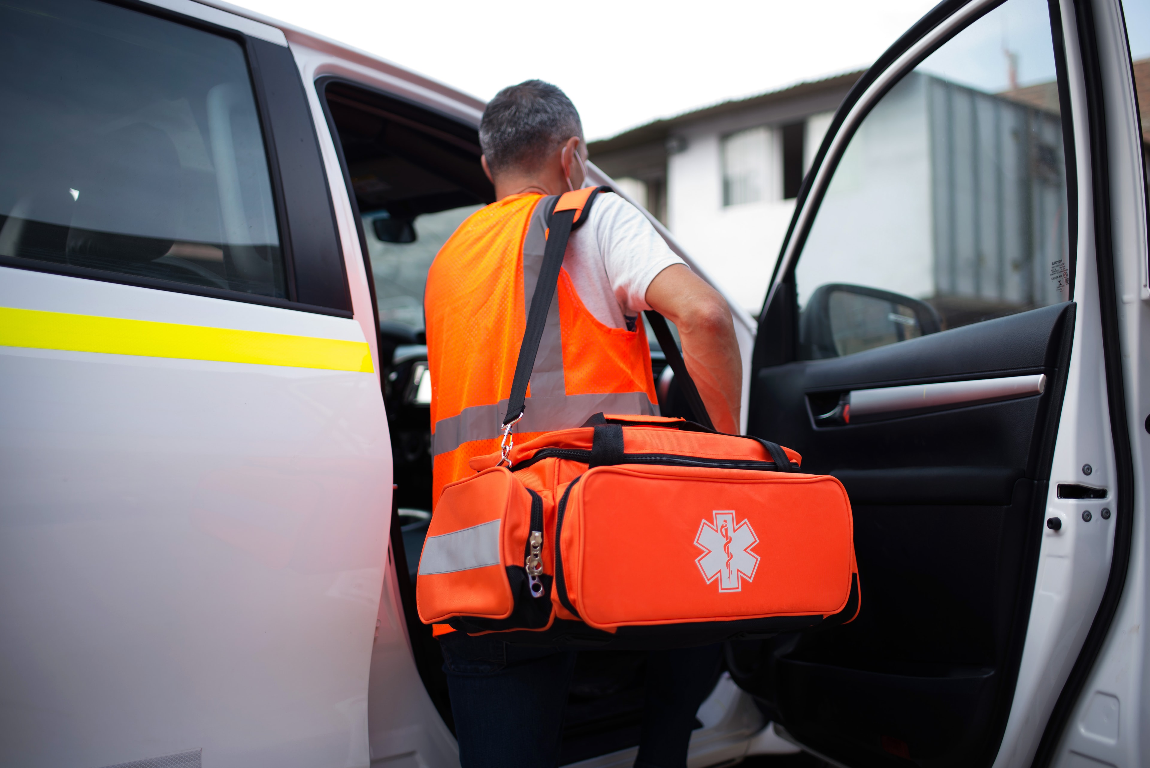Brigadista con chaleco naranja portando maletín de emergencia